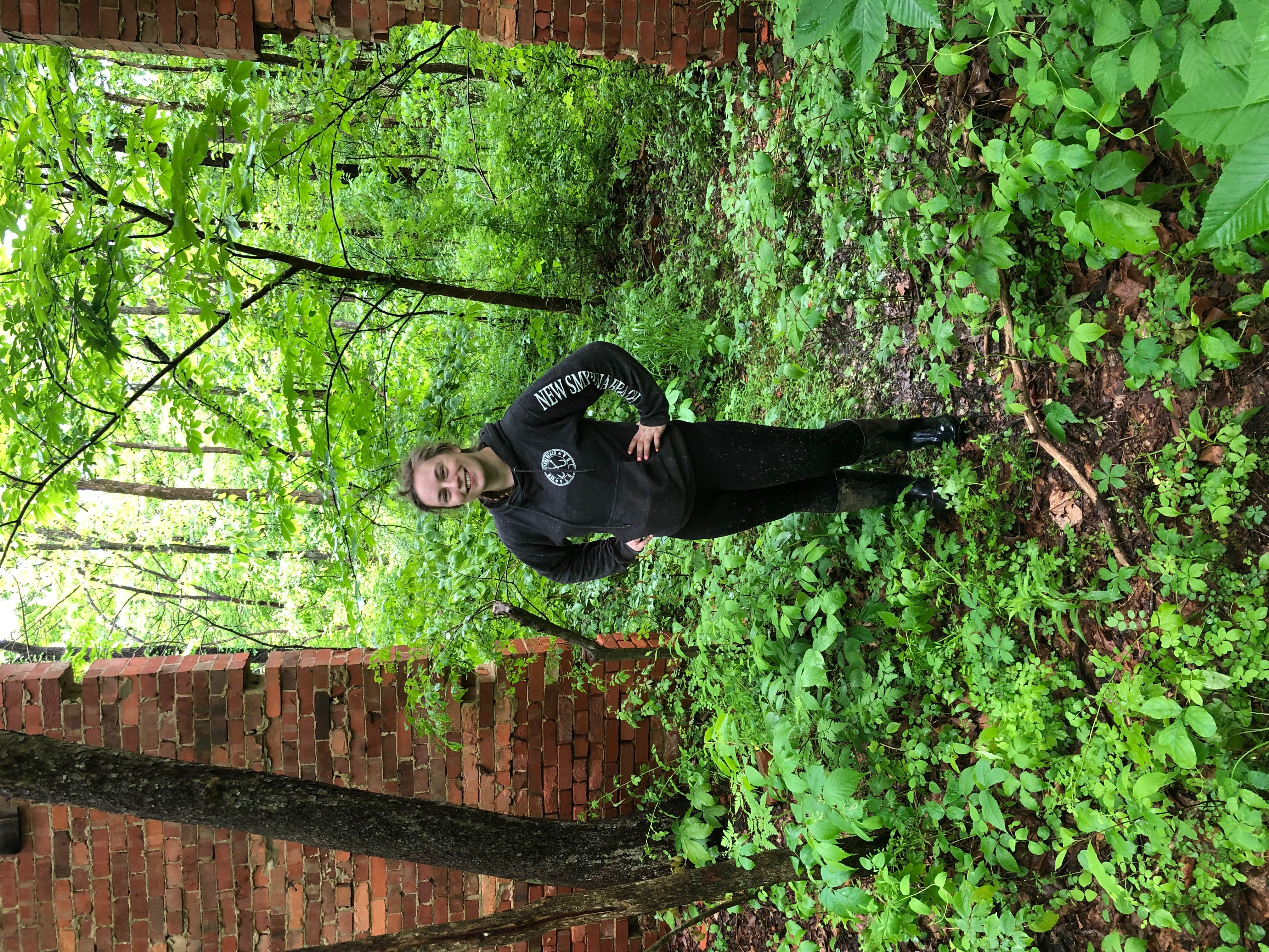 Morgan standing near Brick wall